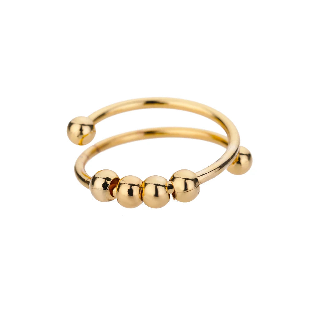 Gold-tone open spinner ring with four sliding beads and ball ends, on white
