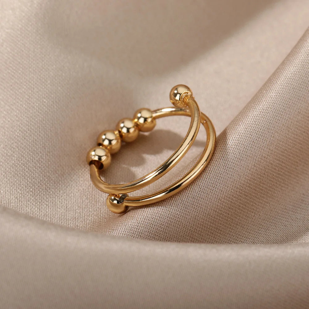 Gold bead spinner ring shown open on a cloth