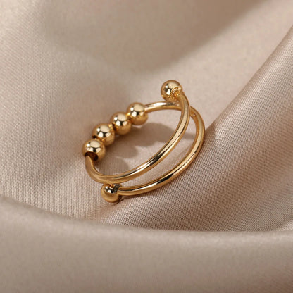 Gold bead spinner ring shown open on a cloth