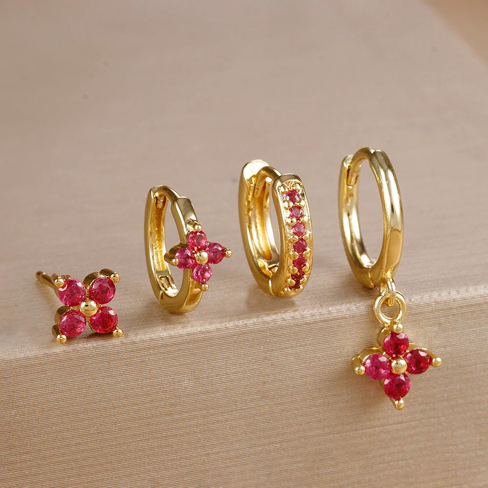 Gold-tone four-piece ear stack with red stones: flower stud, flower huggie, pavé huggie and flower drop hoop
