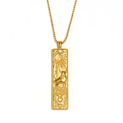 Gold-tone Taurus zodiac bar pendant necklace with engraved bull and a small clear stone, on white
