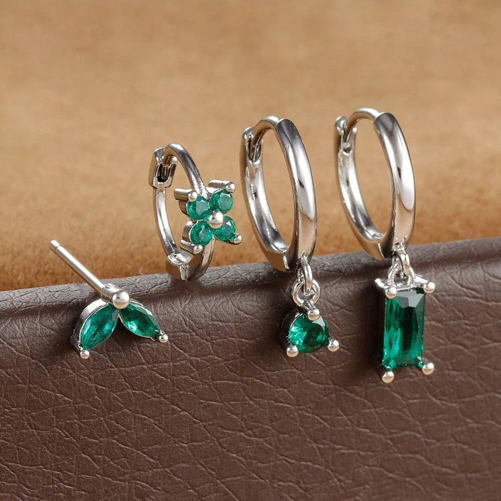 Silver-tone four-piece ear stack with green stones: leaf stud, flower huggie, round drop hoop and baguette drop hoop