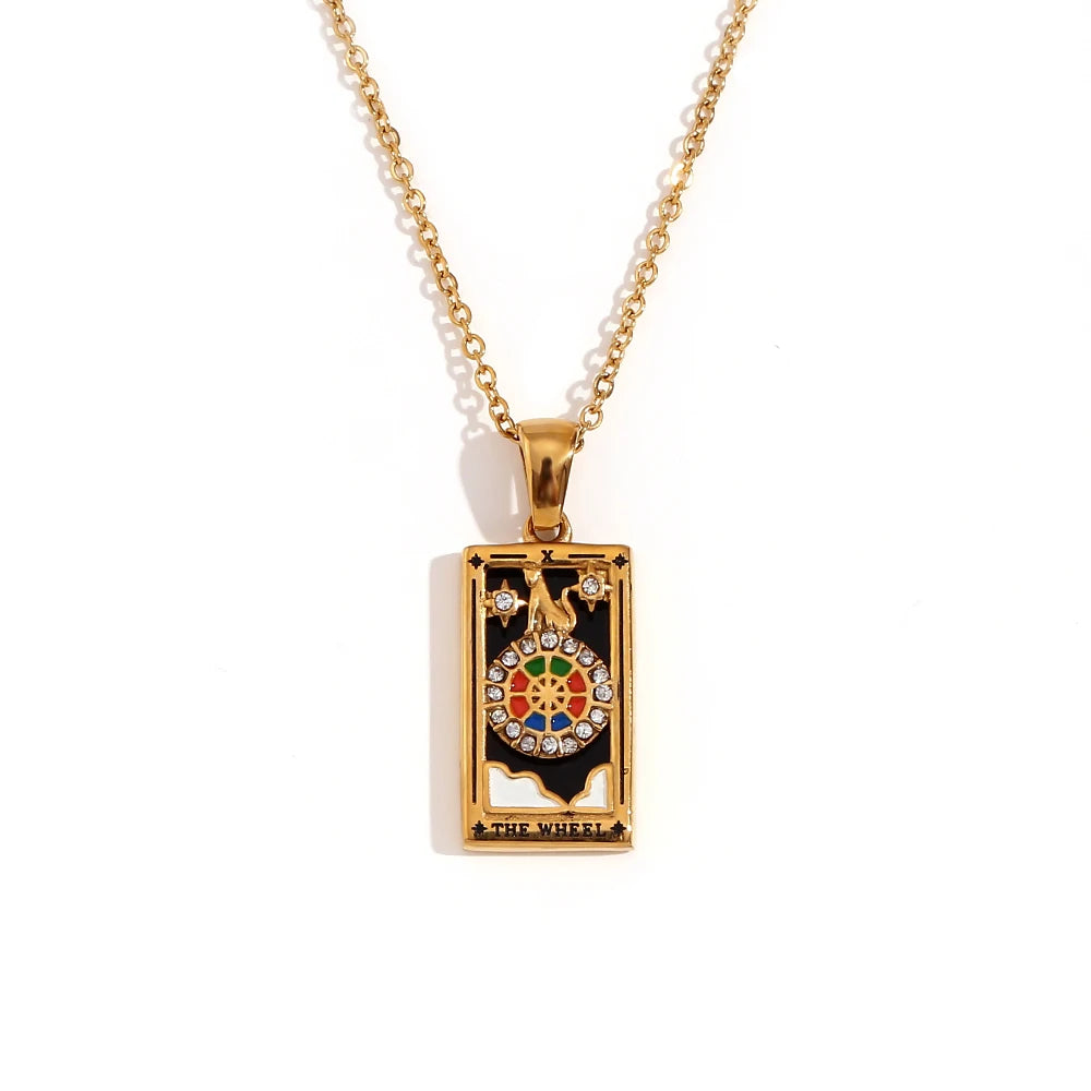 Gold-tone Wheel of Fortune tarot card pendant necklace with black enamel and coloured stones, on white