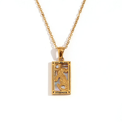 Gold-tone Strength tarot card pendant necklace with cut-out lion design and a small clear stone, on white