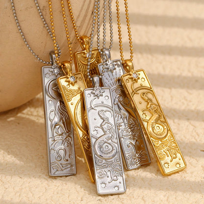 Group of gold-tone and silver-tone zodiac bar pendant necklaces on a beige surface