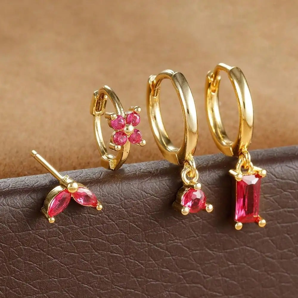 Gold-tone four-piece ear stack with pink stones: leaf stud, flower huggie, round drop hoop and baguette drop hoop