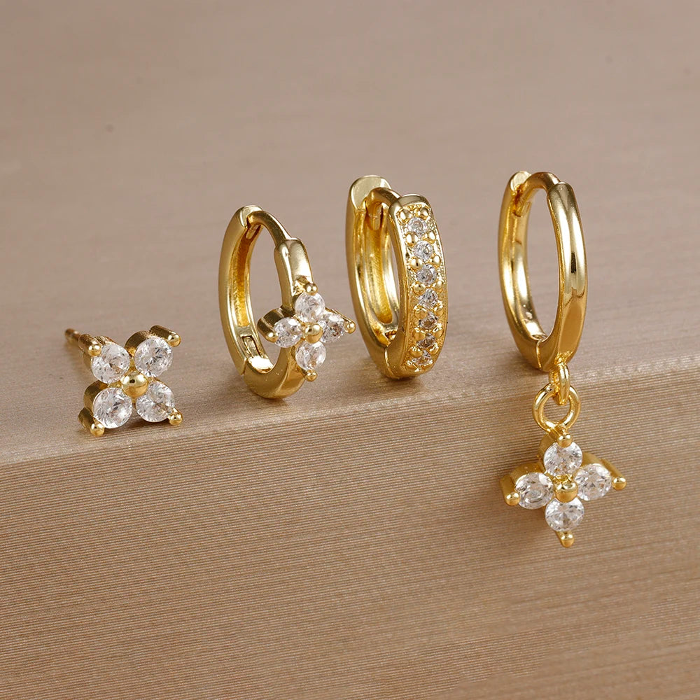 Gold-tone four-piece ear stack with clear stones: flower stud, flower huggie, pavé huggie and flower drop hoop