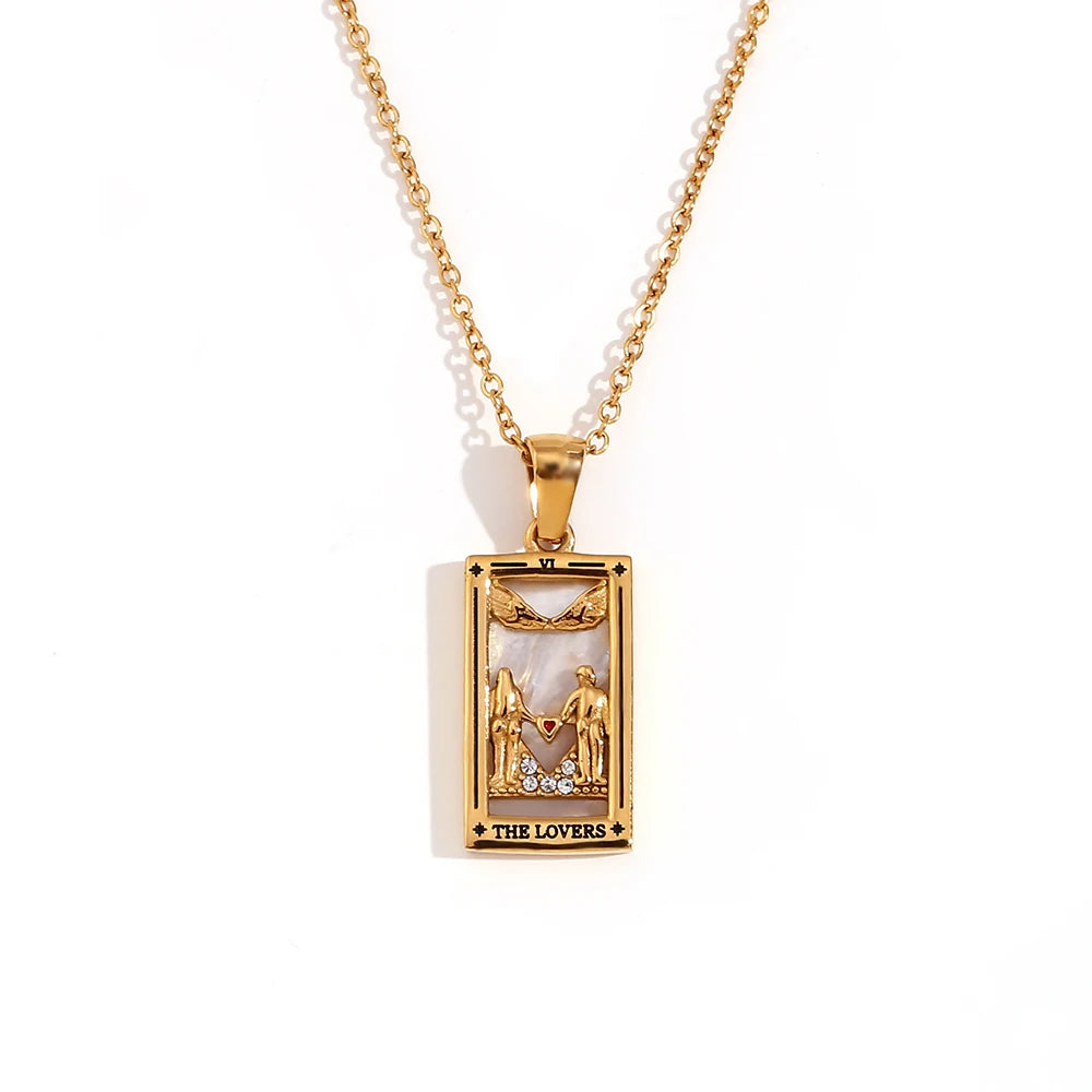 Gold-tone The Lovers tarot card pendant necklace with cut-out figures and small clear stones, on white