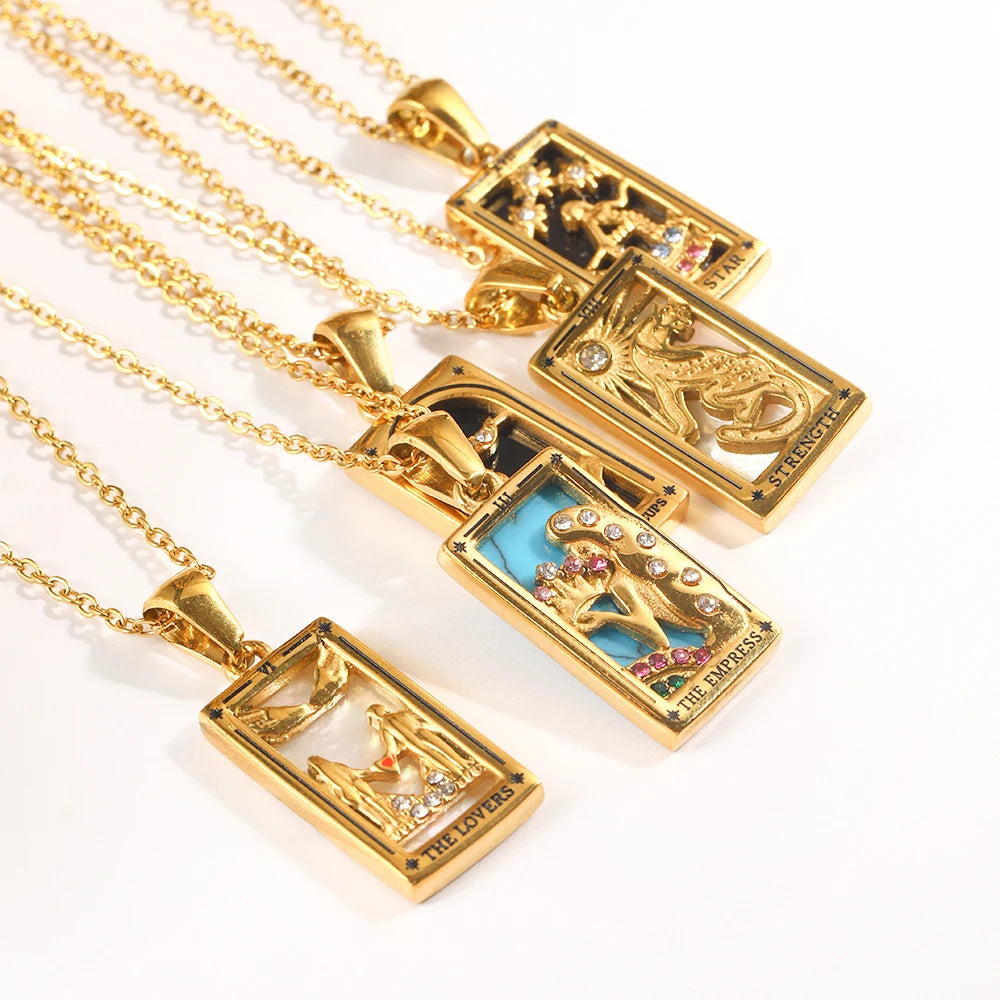 Gold tarot card pendants laid out on a cream surface