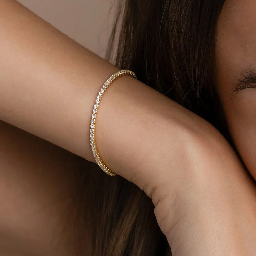 Woman wearing a slim gold tennis bracelet