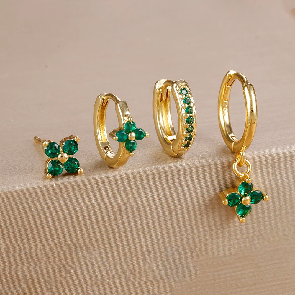 Gold-tone four-piece ear stack with green stones: flower stud, flower huggie, pavé huggie and flower drop hoop