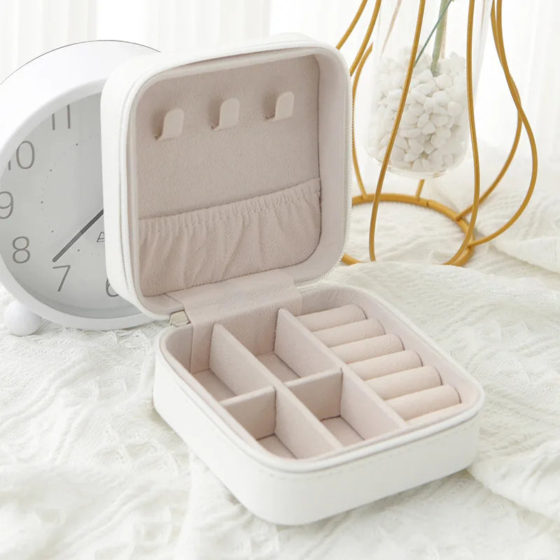 White travel jewellery case, open, with ring rolls and compartments