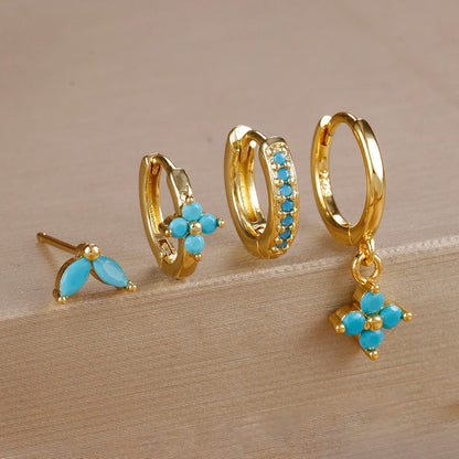Gold-tone four-piece ear stack with turquoise stones: leaf stud, flower huggie, pavé huggie and flower drop hoop