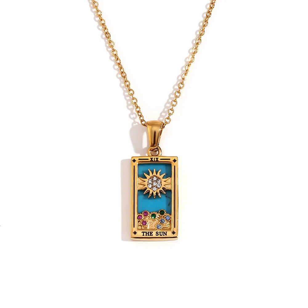 Gold-tone The Sun tarot card pendant necklace with blue enamel, clear and coloured stones, on white