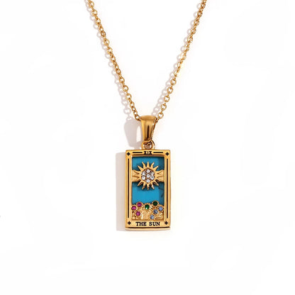 Gold-tone The Sun tarot card pendant necklace with blue enamel, clear and coloured stones, on white